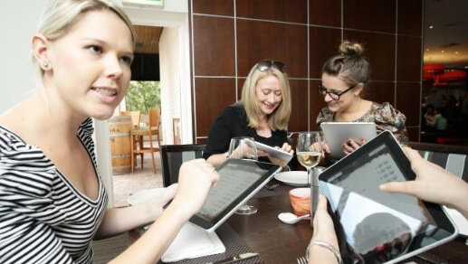 Девушки с iPad в ресторане Девушки с iPad в ресторане